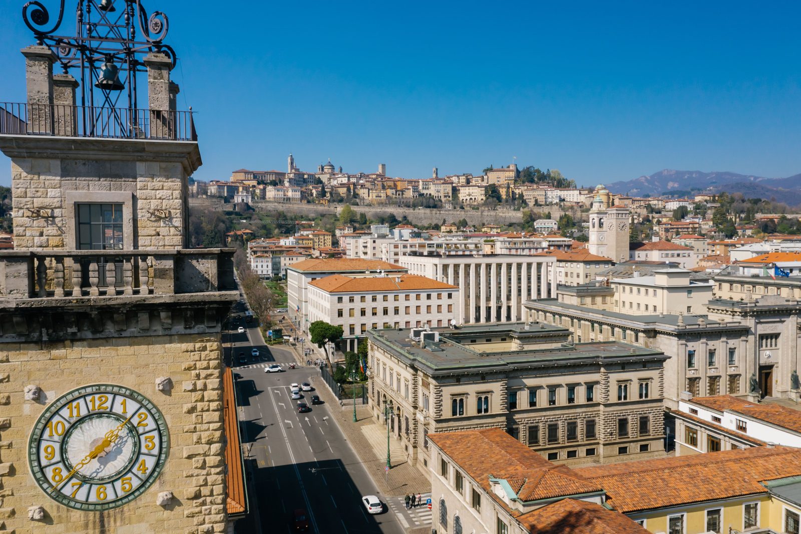 Aerial view of Bergamo with the iconic clock tower and historic architecture on a sunny day.