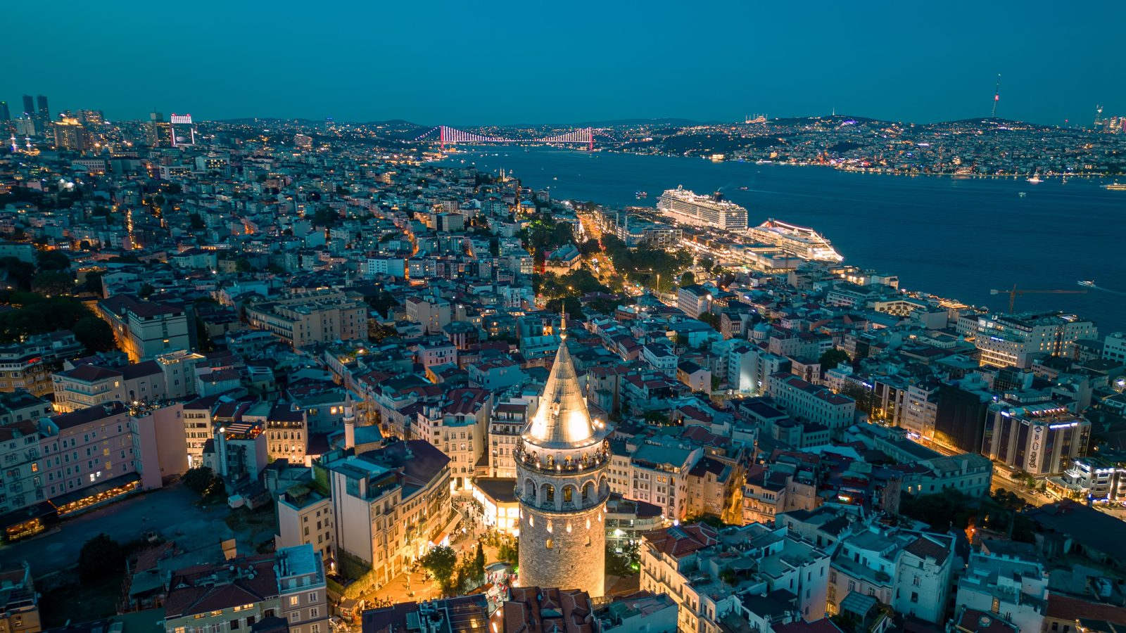 Stunning aerial view of Galata Tower with illuminated Istanbul skyline at night.